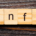 Buchstaben INFO auf hellen Holzplättchen auf dunklem Holzhintergrund