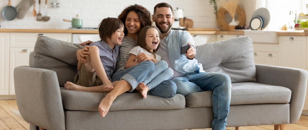 Eine fröhliche vierköpfige Familie auf einer Couch
