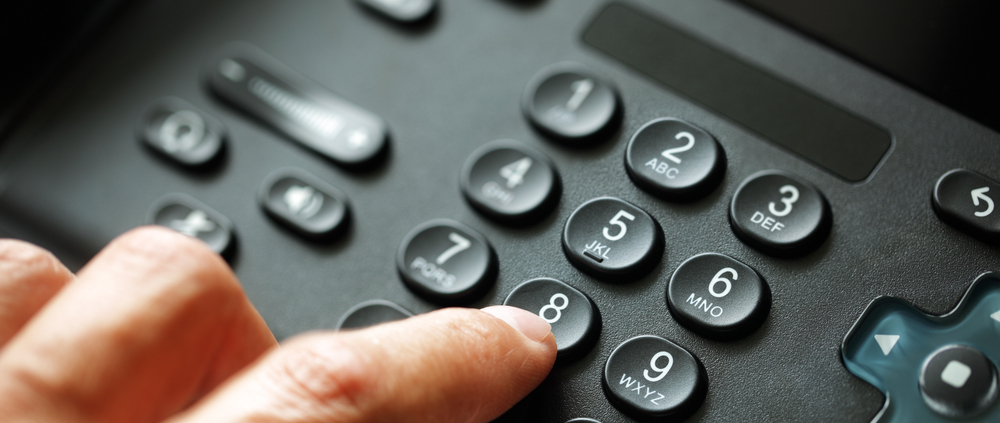 Ein Finger, der Tasten auf einem Telefon drückt