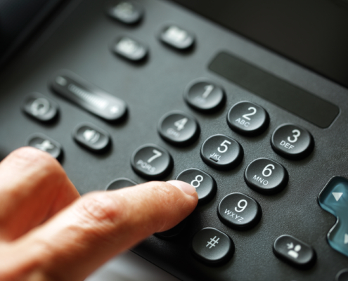 Ein Finger, der Tasten auf einem Telefon drückt