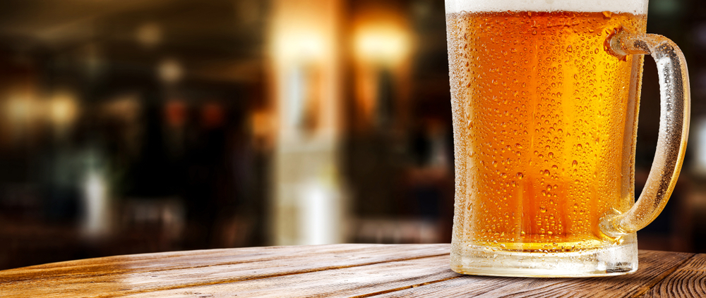 Ein großes Glas frisch gezapftes Bier auf einem Holztisch