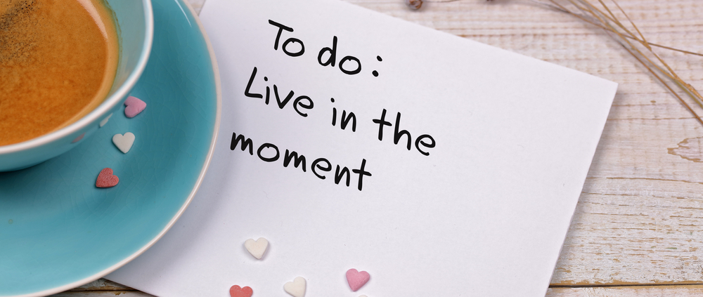 Eine Notiz neben einer Espresso-Tasse. Darauf steht "To do: Live in the moment" (englisch für "Aufgabe: Lebe den Moment")